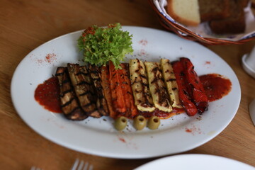 Grilled Vegetables and Salad on a White Plate with Sauce and Garnish
