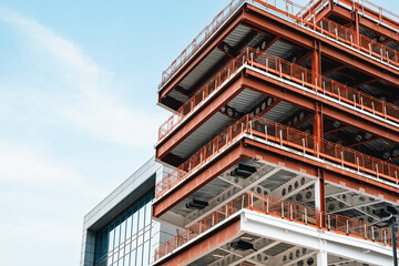 Modern architecture showcases a multi-level building with an innovative design and vibrant orange...