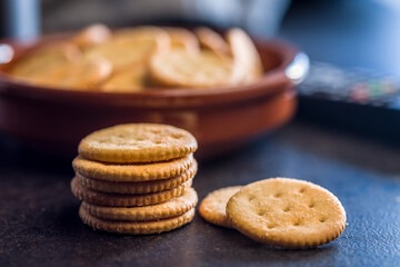 Crispy round salted crackers on black table.