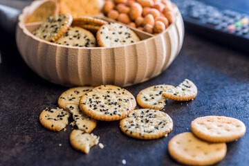 Crispy round salted crackers on black table.