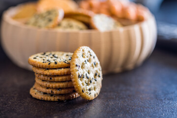 Crispy round salted crackers on black table.