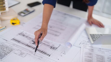 Architect professional examining detailed building blueprints planning construction project design development for future structures office workspace