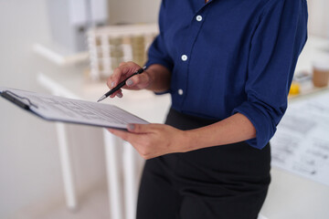 Professional architect meticulously checks project blueprints design plans in modern office workspace ensuring quality construction development