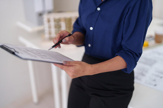Professional architect meticulously checks project blueprints design plans in modern office workspace ensuring quality construction development