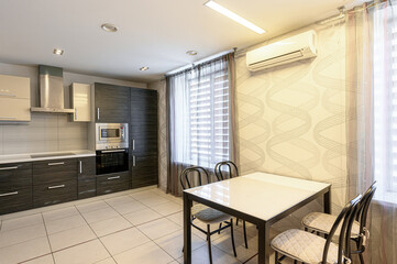 Bright kitchen with a dining table, cabinets, and modern appliances. The walls are decorated with a...