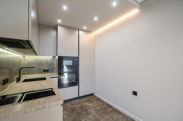well-lit modern kitchen with sleek cabinets, marble countertops, built-in appliances, and recessed...
