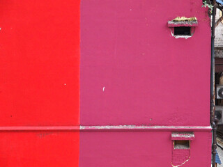 Red and purple painted walls with square holes and small awnings.