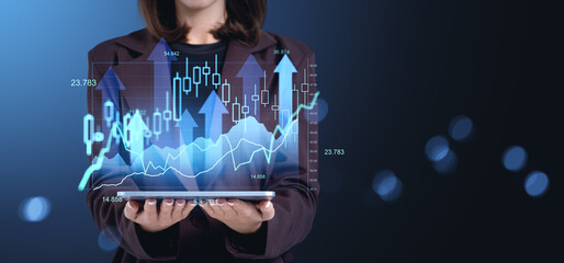 Businesswoman holding tablet with financial stock market charts