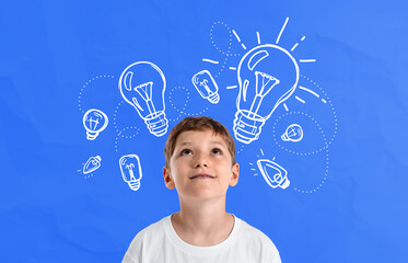 Curious boy imagining ideas with drawn light bulbs on blue backg