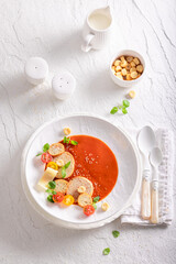 Exquisite tomato soup decorated with crostini, herbs and spices.