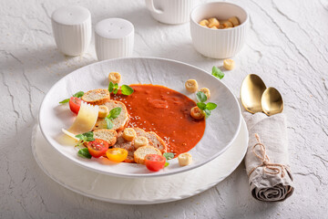 Exclusive tomato soup decorated with crostini, herbs and spices.