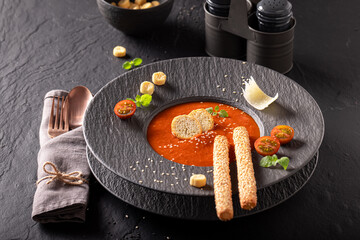 Professional tomato soup decorated with crostini, herbs and spices.