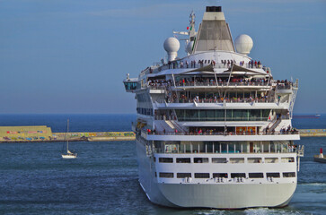 Club cruiseship cruise ship liner Vita departure sail away from Barcelona, Spain during summer Mediterranean cruising with historic old town skyline in background and port infrastructure