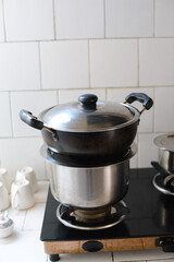 Cooking pans over a gas stove in a mini kitchen low budget home