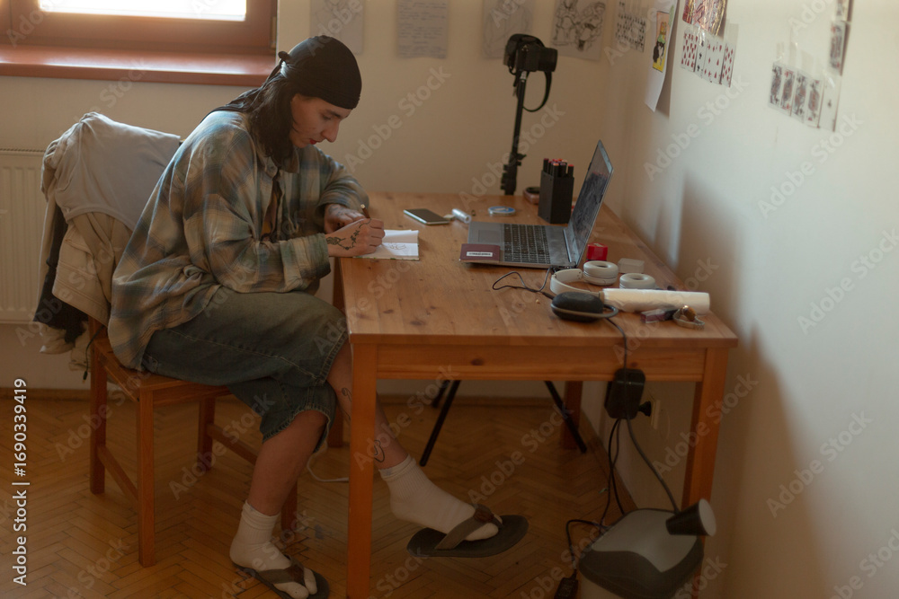 Poster a man is seated at a desk, with a laptop open in front of him, while he is also glancing intently at