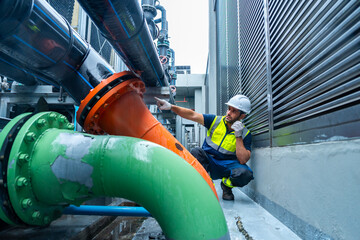 Industrial engineering technician worker working maintenance building exterior plumbing systems....