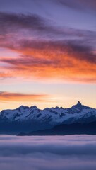 Obraz premium Snow-capped mountains at sunset above a sea of clouds