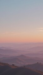 Obraz premium Soft pastel sunset over layered purple mountain ranges
