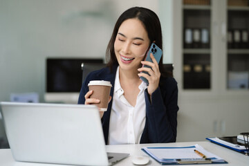 Business women talk mobile phones appointment reminders in calendar on interface. working on laptop...