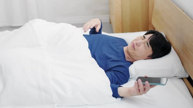 スマートフォンの時刻を見て驚く若い男性　ライフスタイルイメージ