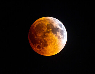 Fototapeta premium Lunar eclipse with reddish orange glow