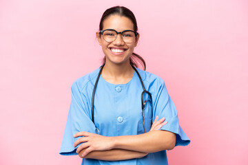 Young nurse Colombian woman isolated on pink background keeping the arms crossed in frontal position
