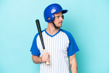 Baseball player with helmet and bat isolated on blue background looking to the side