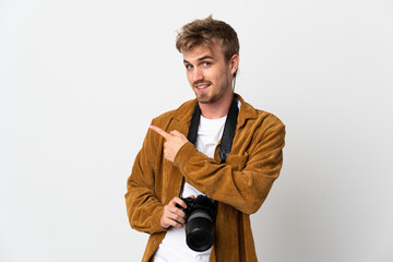 Naklejka premium Young photographer blonde man isolated on white background pointing to the side to present a product