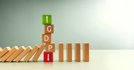 GDP letters on Wooden blocks stacked, green upward and red downward arrows, surrounded by falling...