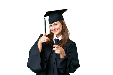 Middle age university graduate woman over isolated background pointing to the front and smiling