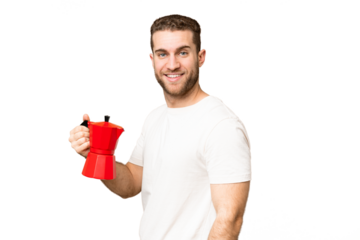 Young handsome blonde man holding coffee pot over isolated chroma key background smiling a lot