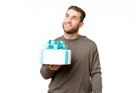 Young handsome blonde man holding birthday cake over isolated chroma key background thinking an idea while looking up