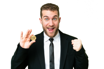 Young business blonde man holding a Bitcoin over isolated chroma key background celebrating a victory in winner position