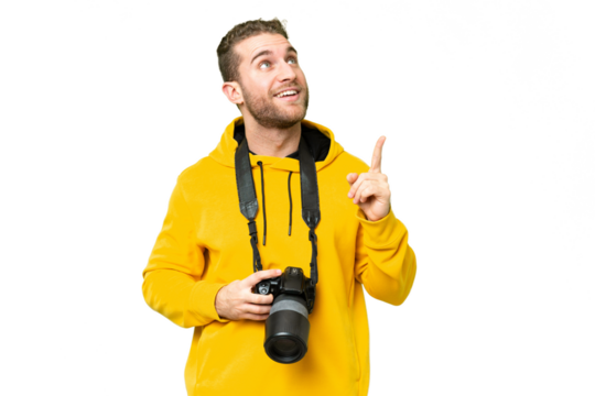 Young photographer man over isolated chroma key background pointing up and surprised