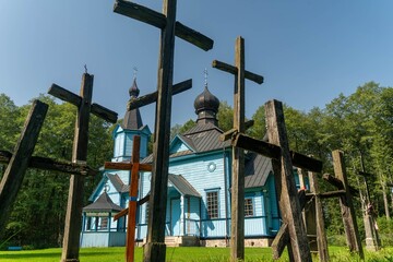 View of wooden crosses and a beautiful blue Orthodox church in Koterka of the Joy of All Who Sorrow Church