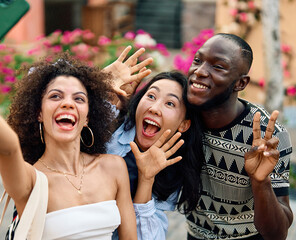 Portrait of group of young people hangout in the city street, taking a selfie photo with a smartphone walking together and having fun.