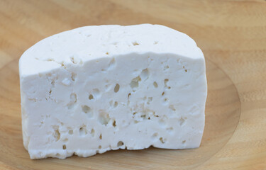 Fresh White Cheese Block on Wooden Plate Closeup