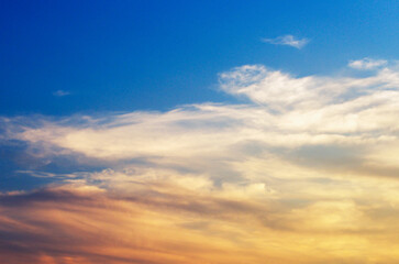 Fototapeta premium Dramatic sunset sky with yellow sunlight clouds on blue sky background in evening time