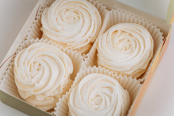 Delicate vanilla marshmallow roses in a gift box, soft light, close-up view