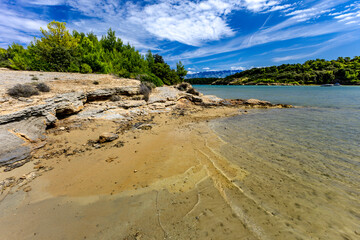 Azure water in the Adriatic Sea, rocky coast of the island of Rab, cloudy, threatening sky, Strucic beach