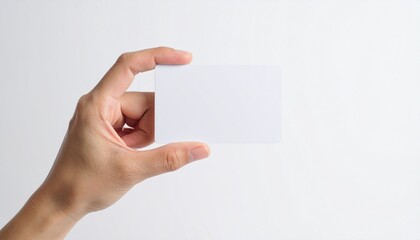 Obraz premium Hand holding a blank business card against a white background Perfect for branding