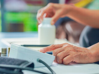 Senior woman is taking notes retirement savings and health care expenses. Retired senior is planning health care and finances, life planning. Elderly care female note and check medicine. Lifestyle 