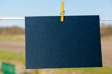 Empty dark blue cardboard on a clothline