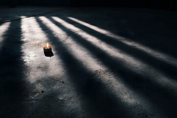 A small candle surrounded by giant shadows, symbolizing hope in darkness. 