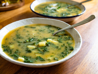 Portuguese green soup - Caldo Verde. Potato and kale soup on wooden table	

