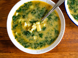 Portuguese green soup - Caldo Verde. Potato and kale soup on wooden table	
