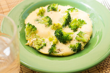 wholesome breakfast. omelet with broccoli on green plate