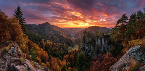 Fototapeta premium A vibrant autumn sunset illuminates a mountainous landscape, showcasing the rich colors of fall foliage and dramatic rock formations, evoking a sense of peaceful grandeur.
