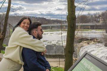 Young Hispanic couple hugging at Paterson Great Falls, New Jersey