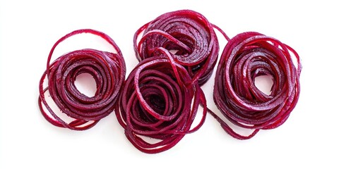 Three vibrant, spiraled ribbons of beetroot are arranged on a white surface. The beetroot is thinly sliced and rolled into tight, circular shapes, revealing its deep crimson color. 
